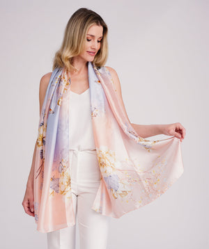 Blush pink oblong scarf featuring a vibrant abstract print for a soft, seasonal statement look. Crafted from lightweight chiffon with a silk-feel finish and delicate hemline edging for a polished drape. Suitable for versatile styling as a neck scarf, shawl, or wrap.