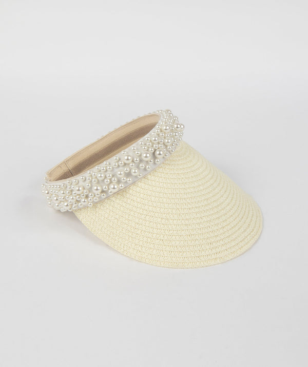 Ivory straw visor with pearl-embellished headband, elasticated adjustable fit, lightweight sun protection accessory for beach and summer wear.
